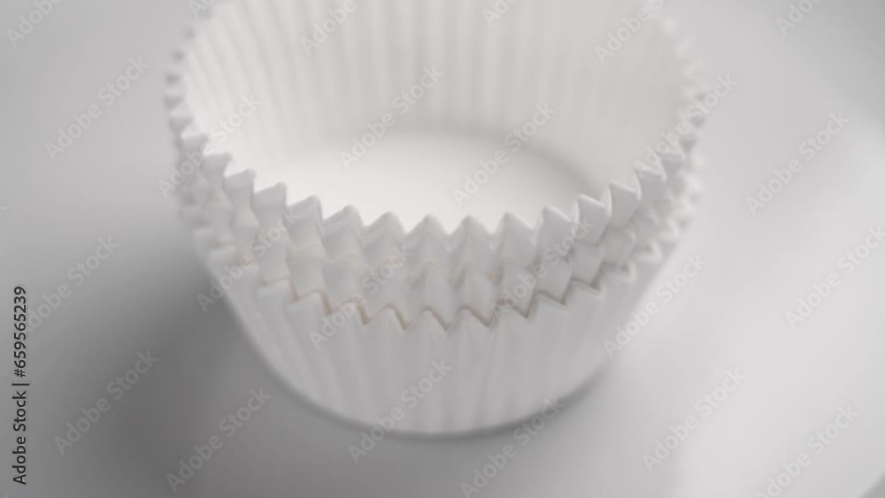 New white baking paper muffin cupcake cups close up. Stacking in slow motion close up New white baking paper muffin cupcake cups close up. Stacking in slow motion close up