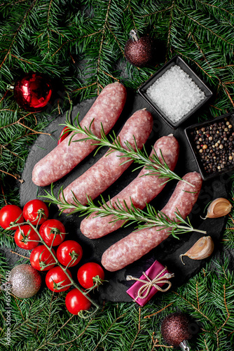 Christmas raw sausages on a background of fir trees and Christmas decorations