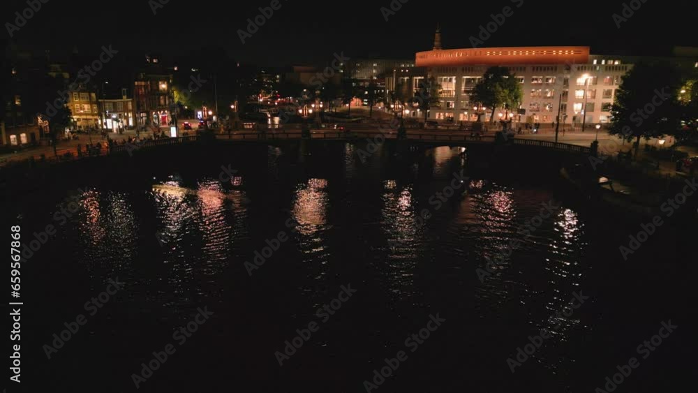 Beautiful night aerial view of Amsterdam downtown from above with many narrow canals, illuminated streets and old historic houses, drone footage Beautiful night aerial view of Amsterdam downtown from above with many narrow canals, illuminated streets and old historic houses, drone footage