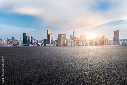 Asphalt road and city skyline with modern buildings scenery at sunset