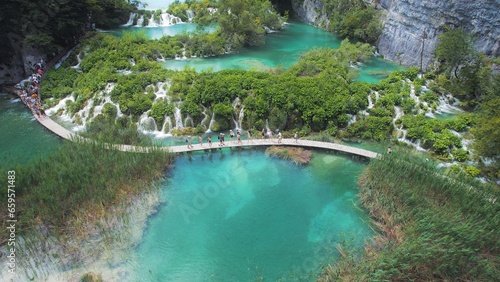 Hiking trail over crystal clear emerald water of lake. Path for tourists in mountain national park with waterfalls.