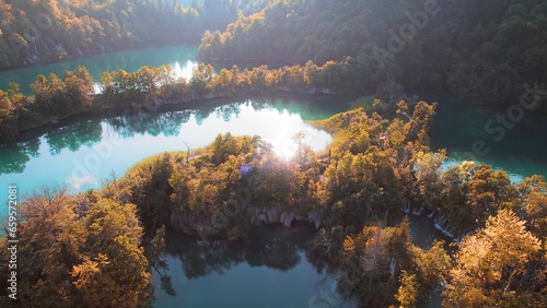 Mountain lake in autumn forest with bright landscape at sunny morning. Clear fresh turquoise water in reservoir.