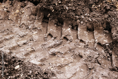Close-up of the imprint of a tank track or construction equipment on the ground.