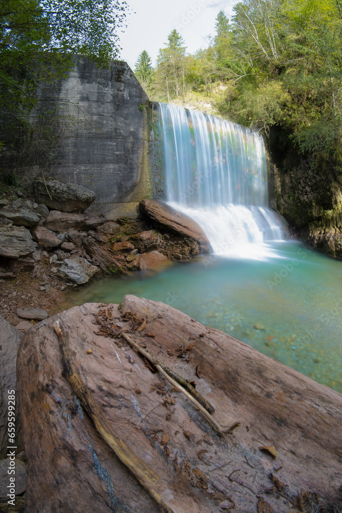 Lonely waterfall, long exposure in the green forest.