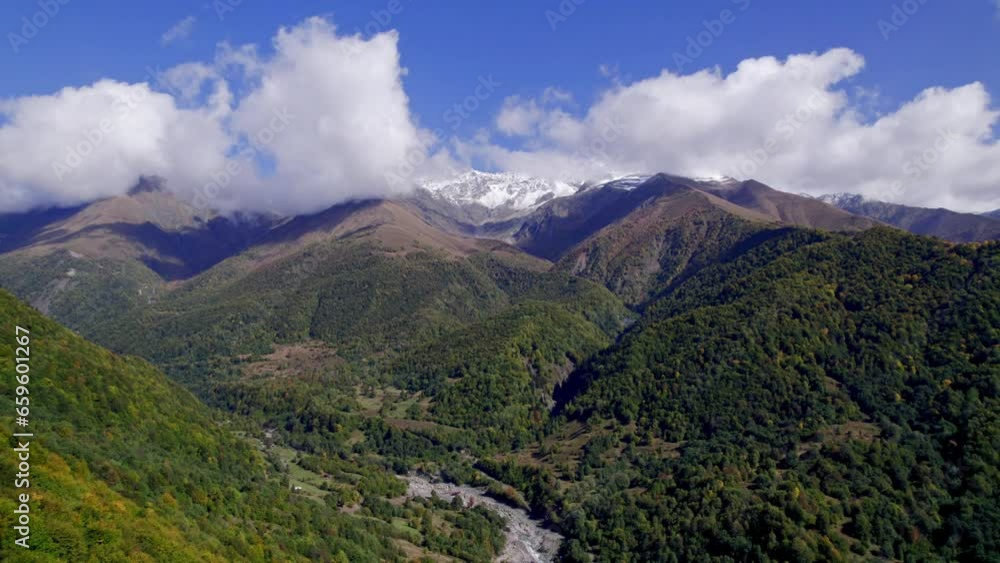 Aerial view of autumn landscape in the mountains with white peaks and blue sky Aerial view of autumn landscape in the mountains with white peaks and blue sky