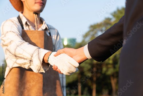 Eco-businessman handshake with farmer, eco-friendly farming practice and clean agricultural technology. Cooperation between farmer and CSR company for farm subsidize with environment protection. Gyre