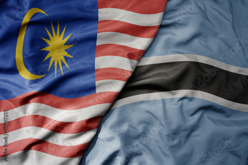 big waving realistic national colorful flag of malaysia and national flag of botswana .
