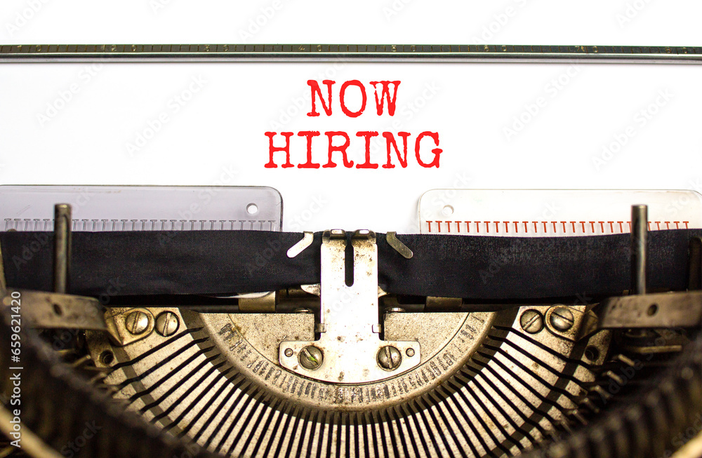 Now hiring symbol. Concept words Now hiring typed on beautiful old retro typewriter. Beautiful white paper background. Business marketing, motivational now hiring concept. Copy space.
