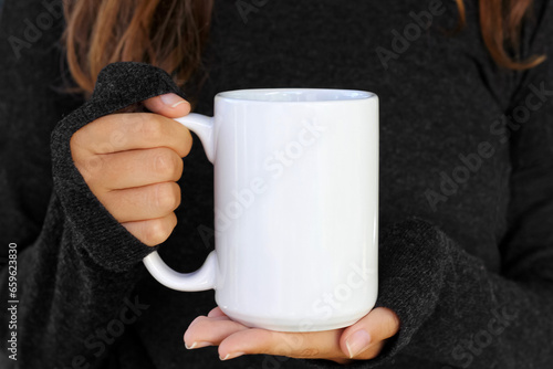 Obraz na plátně Girl is holding white 15 oz mug in hands with black sweater