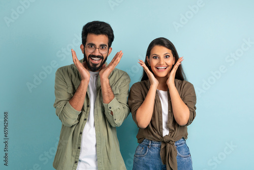 Amazed emotional hindu man and woman gesturing on blue