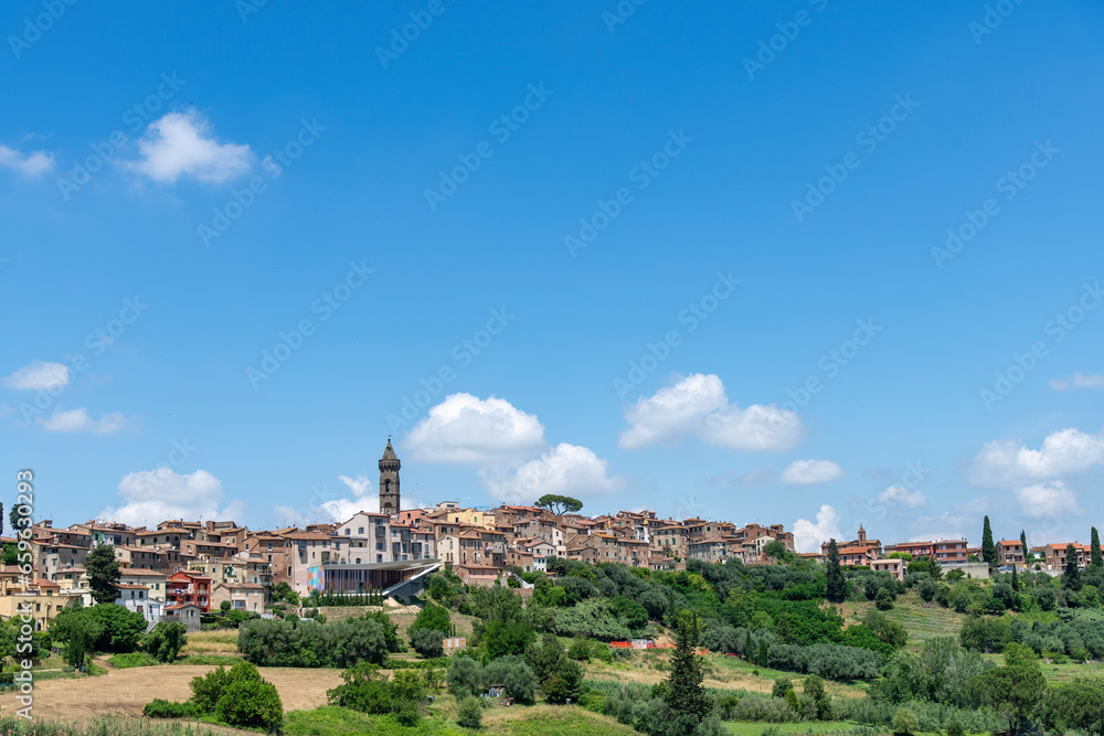 Panoramic view over a hill in the Tuscan landscape with the city of Pecciola, Italy known for its (modern) arts, architecture and history