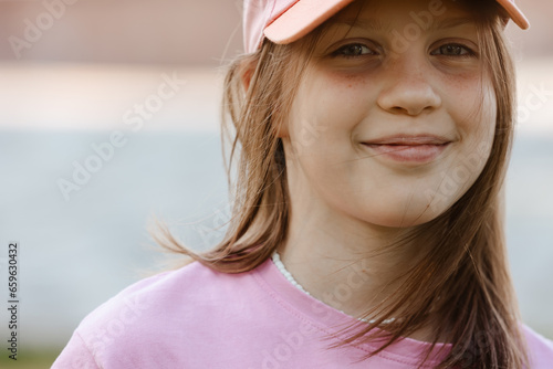 Close up portrait of a ten year old girl, smiling up at the camera. Positive emotion photo