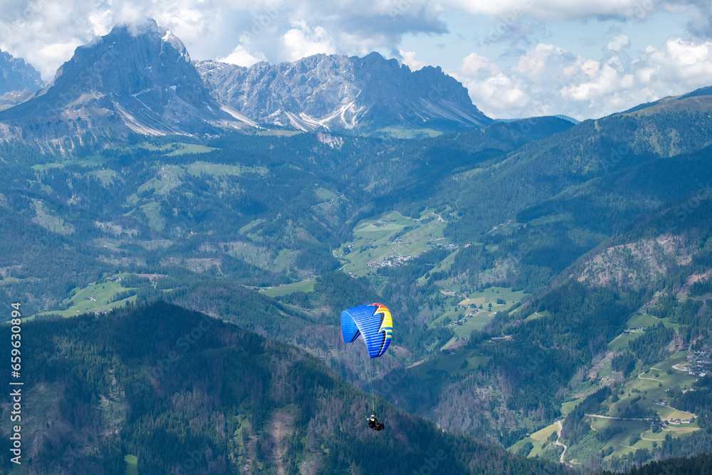 Obraz premium A tandem paraglide from the summit of Kronplatz mountain, Italy, South Tyrol at elevation of 2,275 metres above sea level with dolomites in background