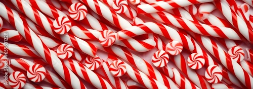White and red shiny Christmas candy canes, minimal flat lay pattern background.