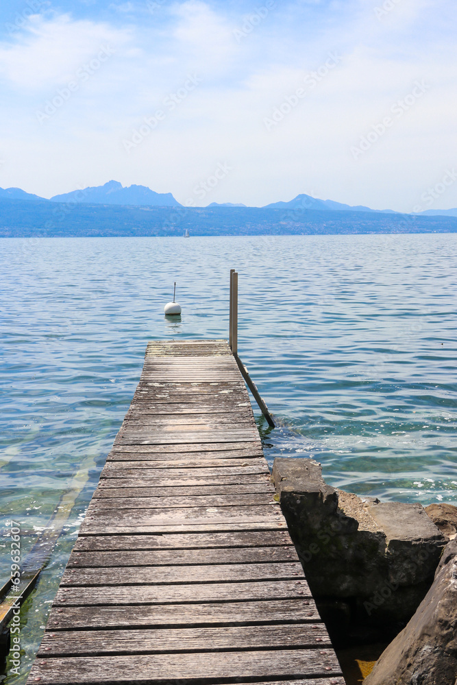 Fototapeta premium Wooden pier overlooking the Alps and Lake Geneva in Switzerland