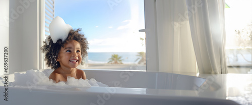 banner bath time, little african American child girl taking bubble bath in beautiful bathroom, Kids hygiene, Shampoo, hair treatment and soap for children, Kid bathing in large tub , foam in hair. photo