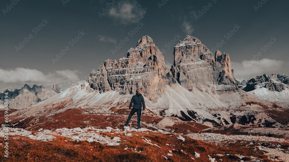 Obraz premium Amidst the breathtaking majesty of the Dolomite Mountains, a rugged and intrepid man stands in awe of nature's grandeur.