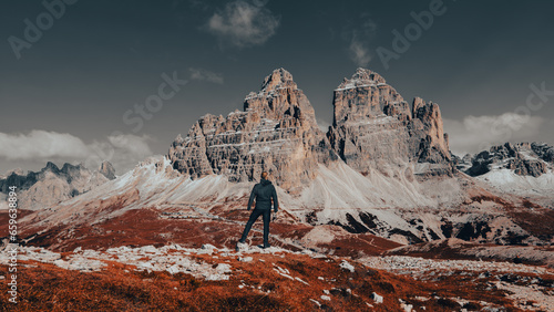 Amidst the breathtaking majesty of the Dolomite Mountains, a rugged and intrepid man stands in awe of nature's grandeur. © Igor