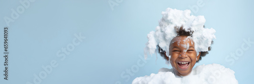 banner copyspace Little smiling african American child boy with big soap foam on head in hair. on solid blue background, Kids hygiene, Shampoo, hair treatment and soap for children, Kids bathing time.