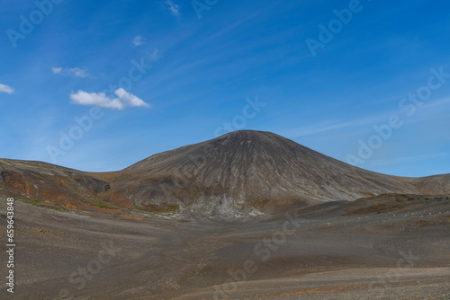 Panoramic view over volcanic landscape on Reykjanes Peninsula, Iceland, near sites of 2021 and 2022 eruptions near mountain Fagradalsfjall volcano area against a white clouded blue sky