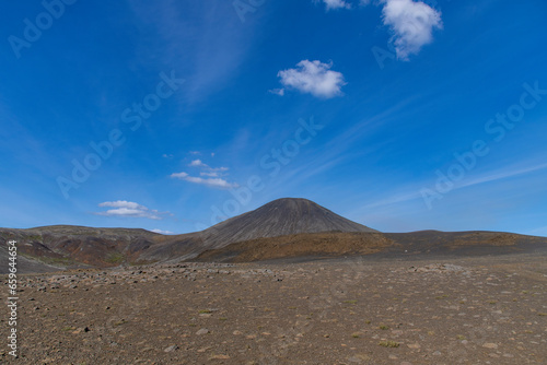 Panoramic view over volcanic landscape on Reykjanes Peninsula, Iceland, near sites of 2021 and 2022 eruptions near mountain Fagradalsfjall volcano area against a white clouded blue sky