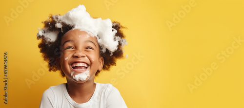 banner copyspace Little smiling african American child boy with big soap foam on head in hair on solid yellow background, Kids hygiene, Shampoo, hair treatment and soap for children, Kids bathing time