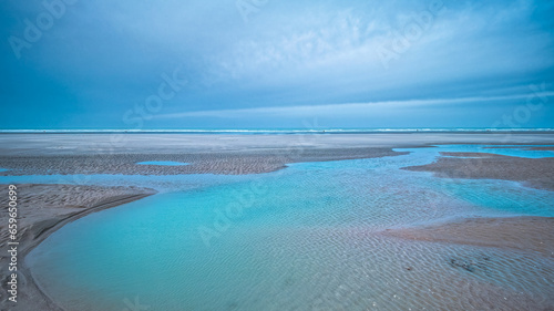 View of turquoise water on a beach at low tide in Upper Normandy, France