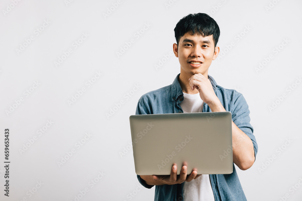 A closeup portrait of a thoughtful Asian man, hand on chin, holding a laptop, pondering questions and looking away. Studio shot isolated on white, where success is born from deep thinking. A closeup portrait of a thoughtful Asian man, hand on chin, holding a laptop, pondering questions and looking away. Studio shot isolated on white, where success is born from deep thinking.