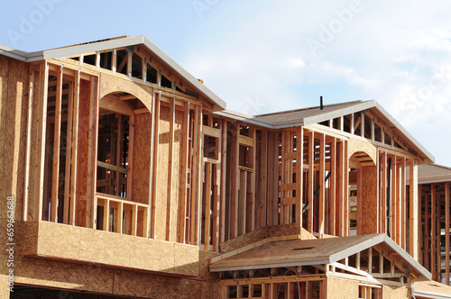 A close-up view of a wooden two-story home under construction in a new subdivision