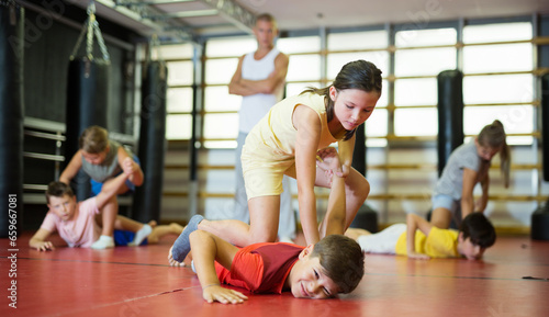 Kids training armlock move during group self-protection training.