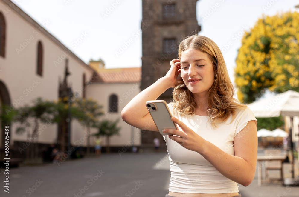 happy woman walking and using a smart phone on a city street happy woman walking and using a smart phone on a city street