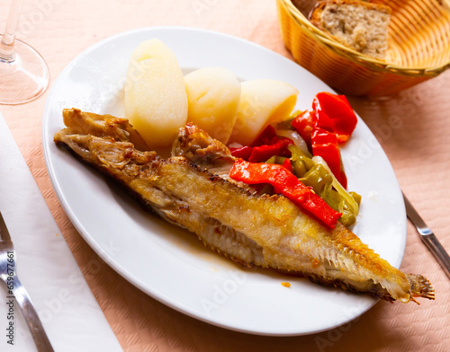 Dish of spanish cuisine - roasted maragota fish (ballan wrasse) with vegetables photo