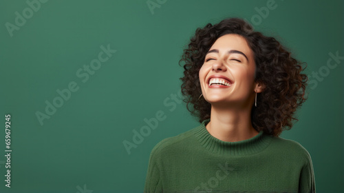 Confident mature woman in casual clothing with copy space. Successful smiling woman with big grin looking at camera. Beautiful positive businesswoman standing against green background © PaulShlykov