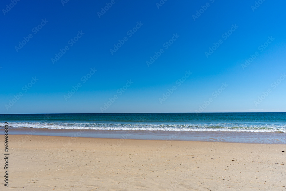 View of idyllic nature landscape with huge beaches and waves crashing on. Manta Rota beach. West Atlantic coast of Algarve region, south of Portugal.