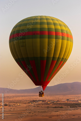 Hot balloon flying at sunset over the Atlas Mountains in the desert of Morocco  © Antoine