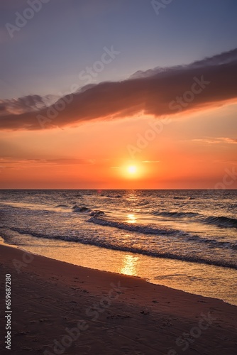 Beautiful colorful sunset over the sea. Sandy beach in the evening on the Polish Baltic Sea.