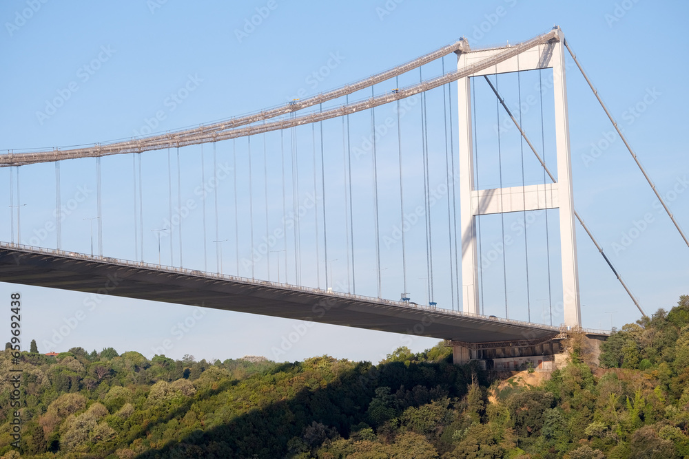 Bosphorus bridge photography from below angle with blue sky, forest and Turkish flag in İstanbul. 