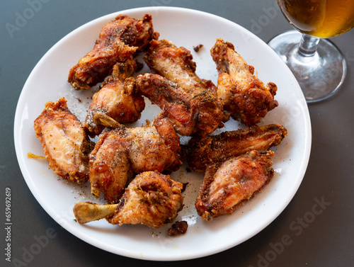 Delicious fried chicken wings with golden crust served with on plate