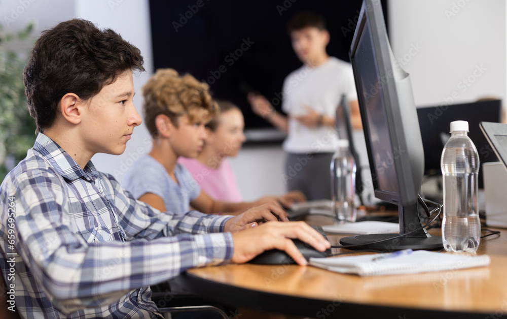 Obraz premium Curious underage boy engaged in IT training during computer courses for children