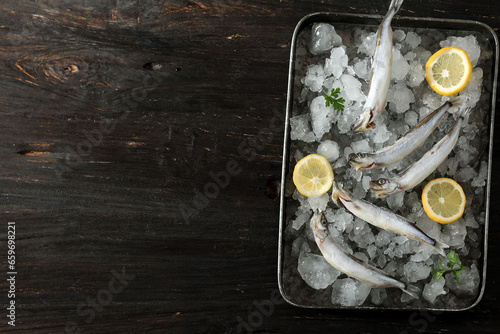 Frozen Capelin Shisamo Fish on Wooden Table, Top View photo