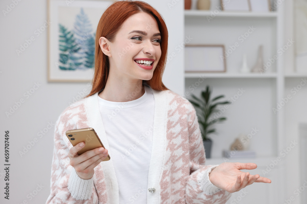 Happy woman sending message via smartphone at home Happy woman sending message via smartphone at home