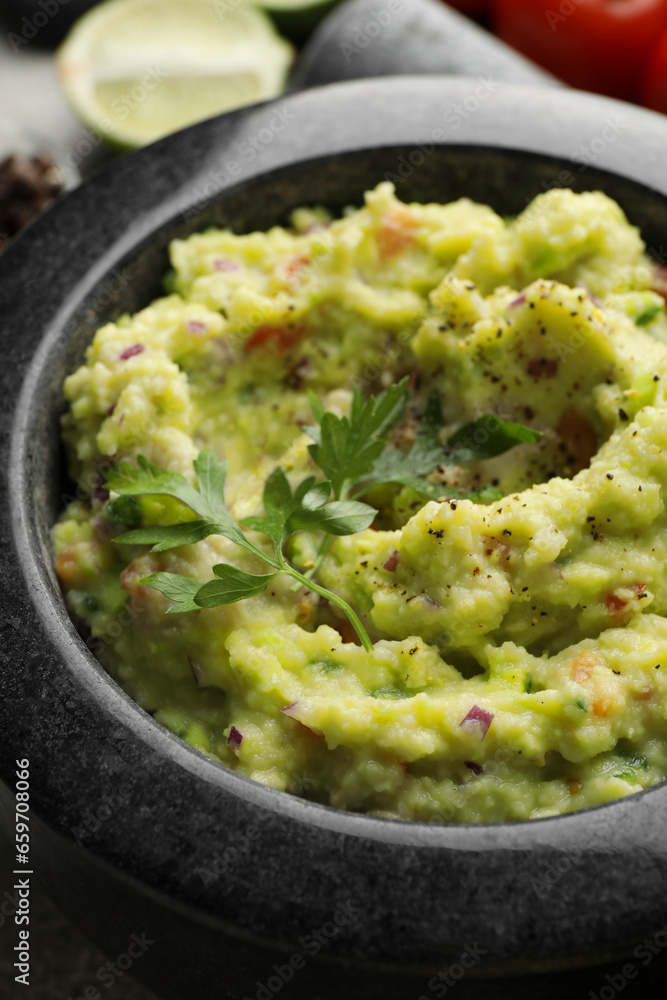 Mortar with delicious guacamole on table, closeup Mortar with delicious guacamole on table, closeup
