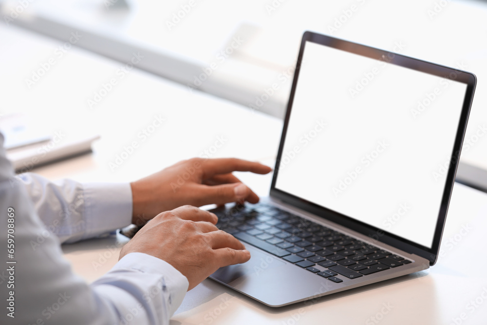 Man using modern laptop at white desk, closeup Man using modern laptop at white desk, closeup
