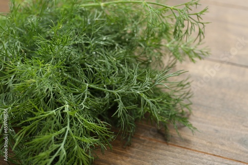 Fresh green dill on wooden table, closeup. Space for text