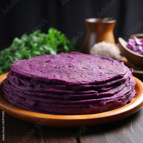 stack of purple pancakes done with ube fruit on a plate over black background