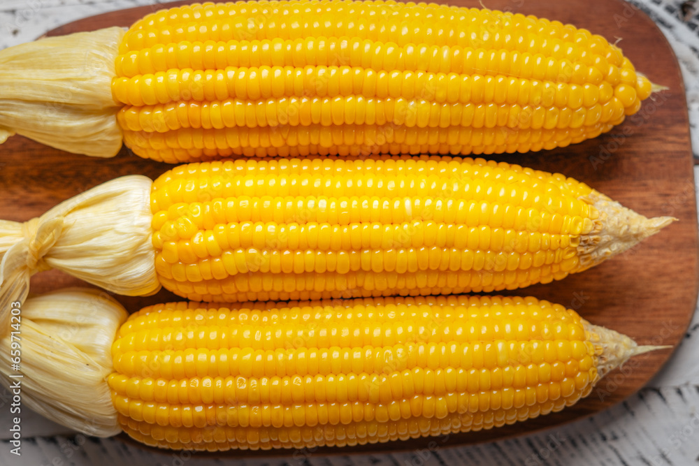 Sweet corn on a wooden cutting board Sweet corn on a wooden cutting board