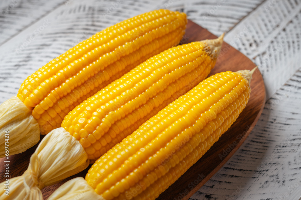 Sweet corn on a wooden cutting board Sweet corn on a wooden cutting board