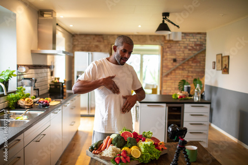 Middle aged African American male food nutritionist filming a video for his blog at home photo