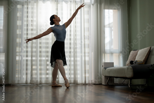 Young ballerina dancing and practicing her movement at home before the show. Tiptoe movements.