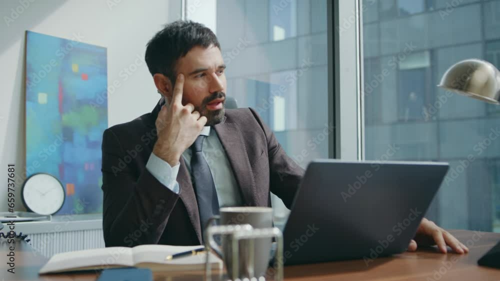 Thoughtful businessman video calling thinking about business at office close up. Thoughtful businessman video calling thinking about business at office close up.